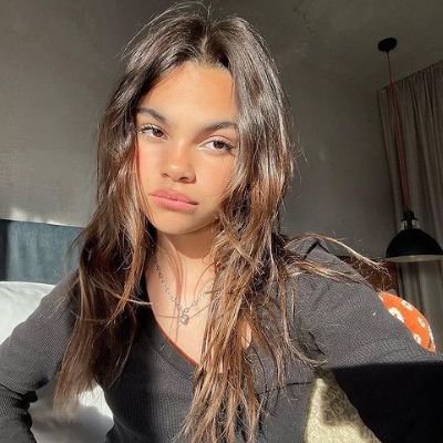 Ariana Greenblatt is wearing a black top in the picture with a necklace.